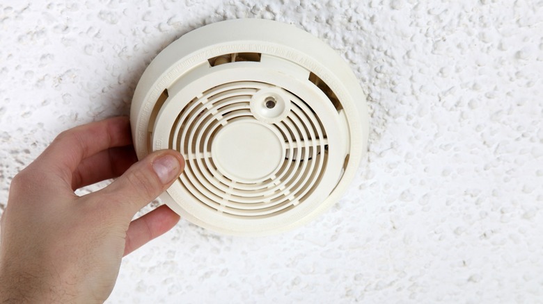 Hand grasping a smoke detector