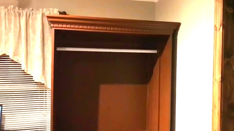 Old cabinet turned into a coat rack with a rod installed inside