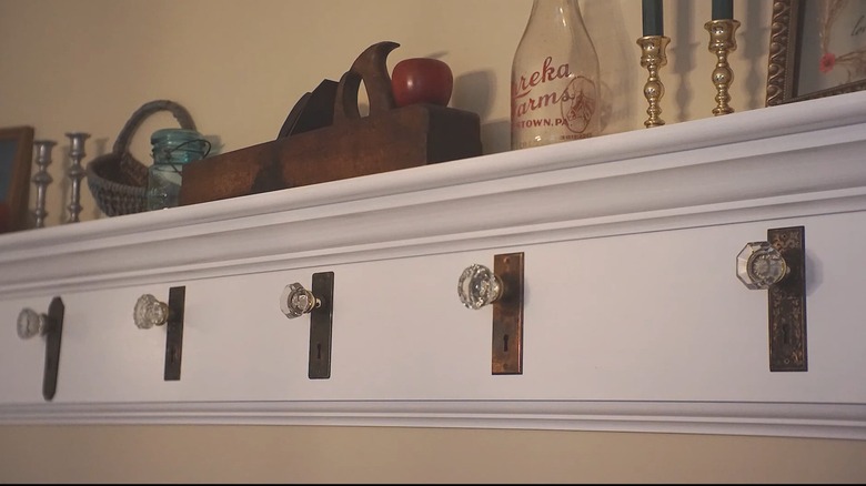 Wooden shelf with old-fashioned doorknobs on it to use as coat hangers