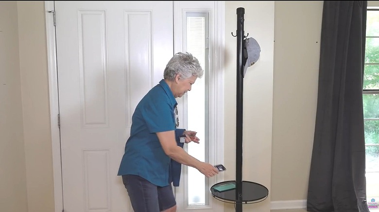Woman putting her phone on the table portion of an upcycled coat rack