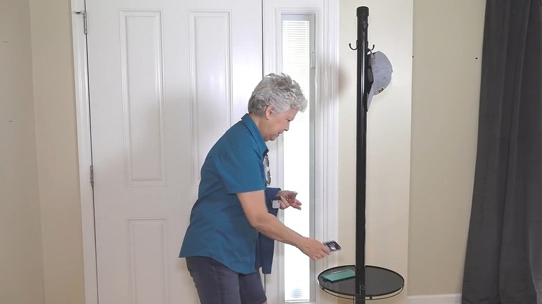 Woman putting her phone on the table portion of an upcycled coat rack