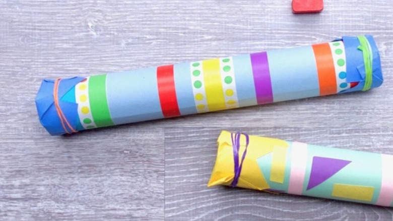 Two colorful musical rainstick crafts on table