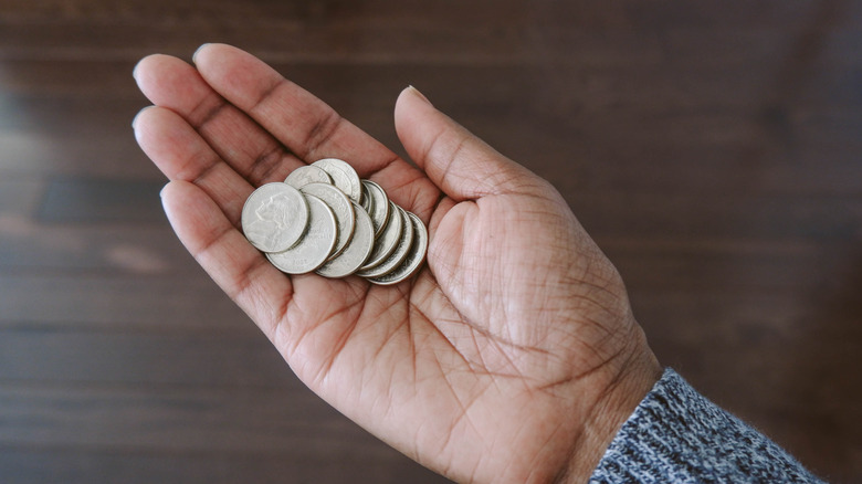 Hand holding multiple silver coins