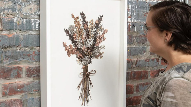 Woman looking at wall art made from coins