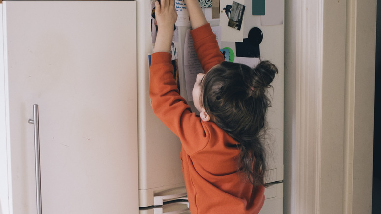 Girl using the magnets on the refrigerator