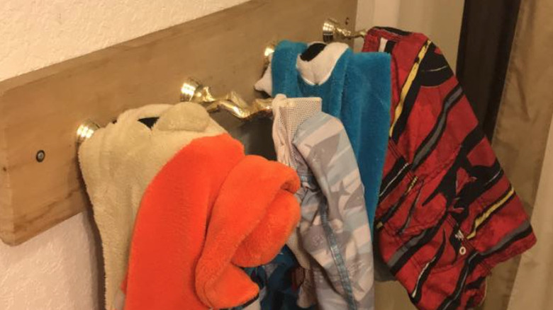 four trophy toppers on a wood board as hooks for clothes