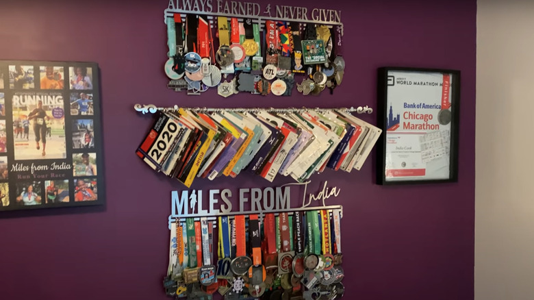 wall collage of different running awards, photos, and track numbers