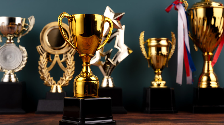 six gold and silver trophies on cabinet