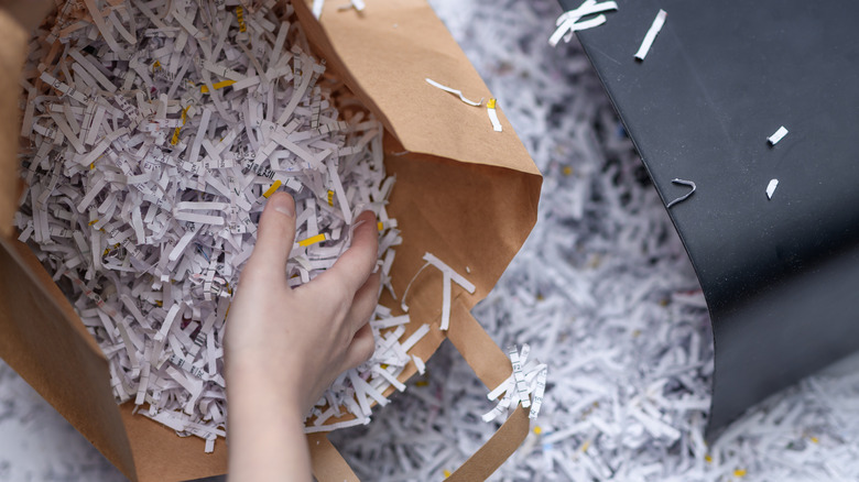 Someone digging through a bag of shredded paper