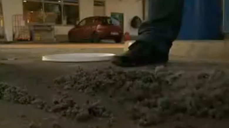 Man next to ground with oil and paper mixture