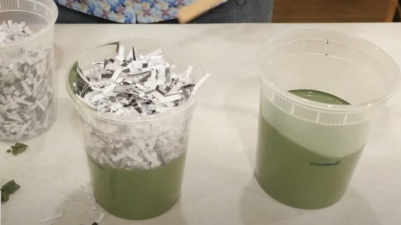 containers filled with shredded paper, green paint, and one with paint and paper