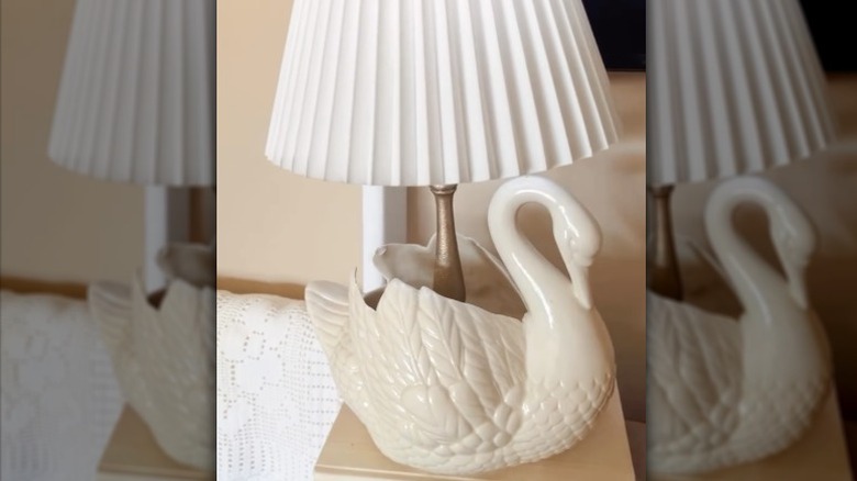 Person making a ceramic swan lamp