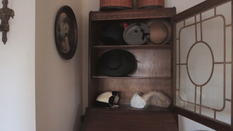 Glass-fronted cabinet full of hats