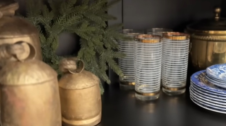 Decorative items in mixed metal tones adorn a shelf.
