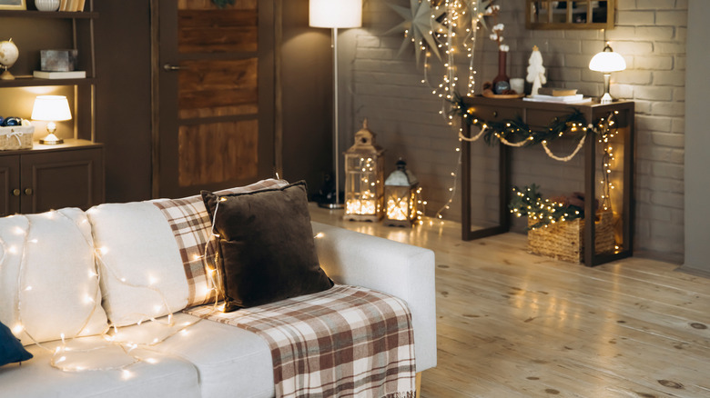 Twinkle lights illuminate a living room decorated for late fall and winter.