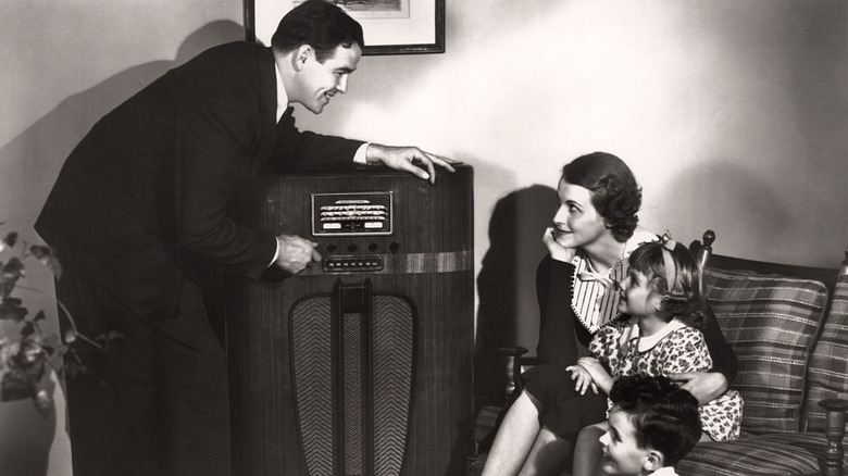 A family in 1935 sits around the radio console