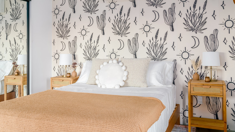 A stunning soutwest style bedroom with a desert theme, including wallpaper with desert flora and the sun and moon