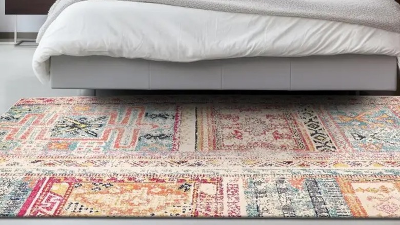 Vibrant patterned rug near a bed