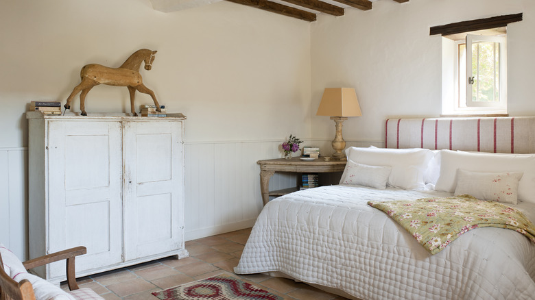 Bedroom with a wooden horse on top of a rustic cabinet