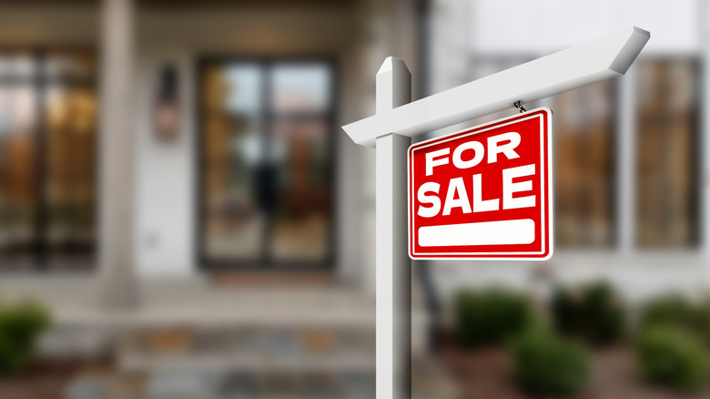 Red for sale sign outside of a house