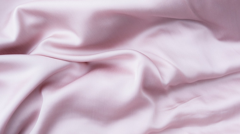 A close up of a pink glossy lyocell fabric