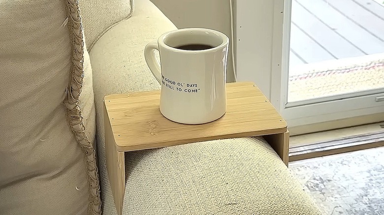 Arm rest made from a Dollar Tree cutting board with a cup of coffee on it