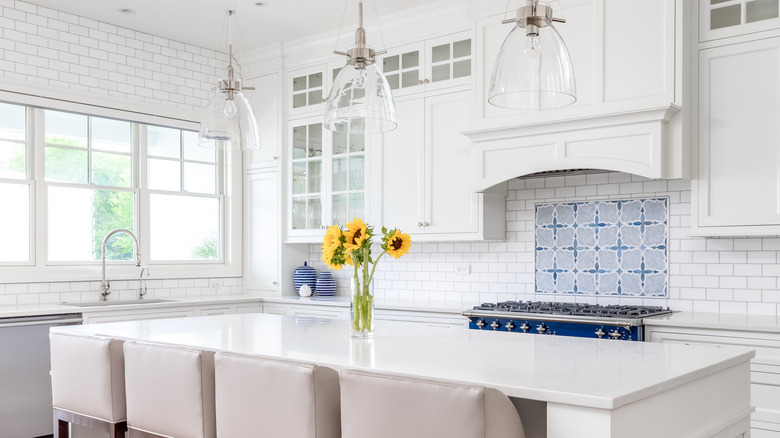 A contemporary kitchen with plain white tiles and patterned backsplash.