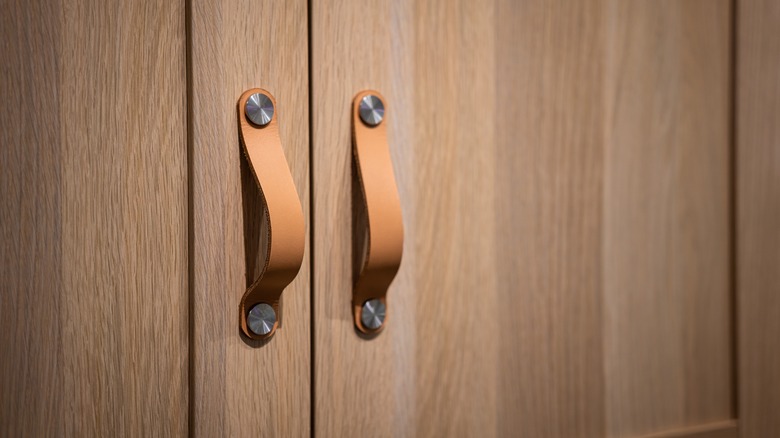 Wooden cupboards with luxury leather door pulls.