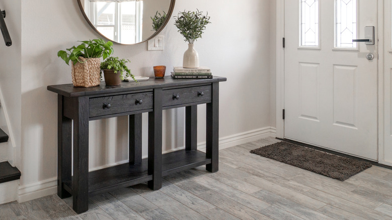 An entryway table with low shelves and drawers for extra storage.