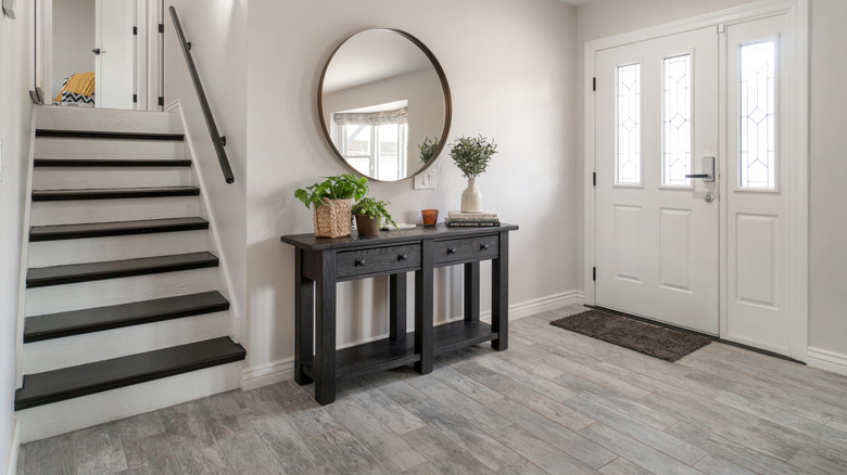 An entryway table with low shelves and drawers for extra storage.
