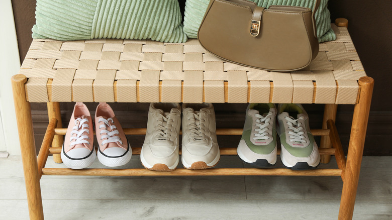 A bench in an entryway with storage shelf underneath.