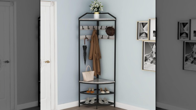 A corner hall tree holds shoes, a bag, a coat, and other accessories by the front door.