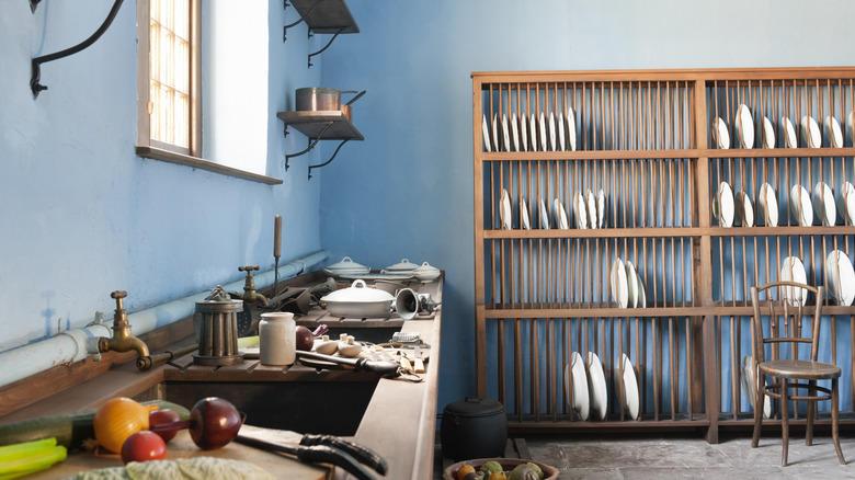 A scullery with various kitchen items and ingredients stored, away from the main kitchen