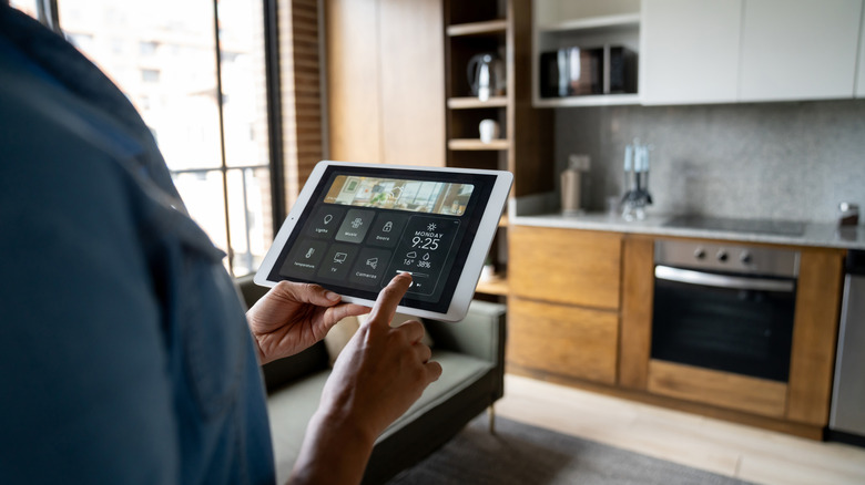 Close-up of a person controlling smart-home devices with a tablet