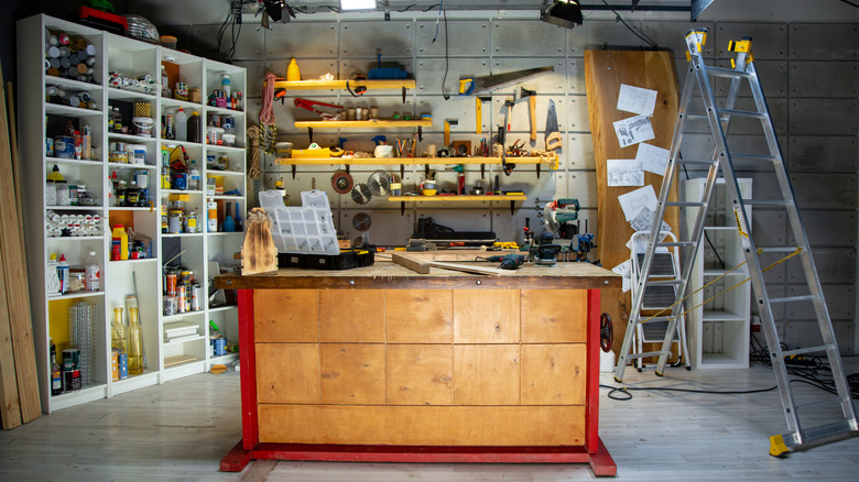 A garage full of DIY tools with a workbench and ladder