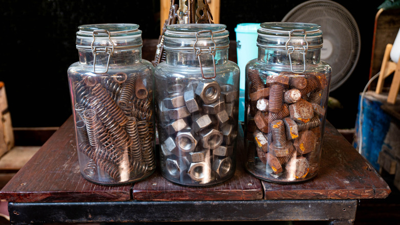 Large glass jars used to store metal springs, nuts, and bolts