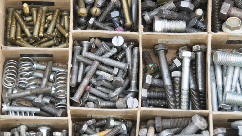 A drawer with dividers used to organize various bits of metal hardware