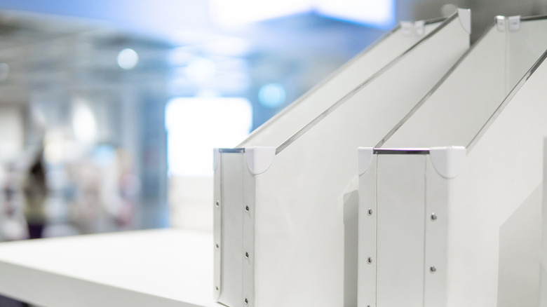 Two white magazine files on a shelf