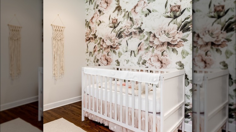 flower wallpaper behind white crib