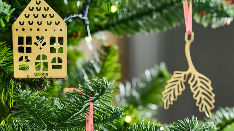 Gold-colored metal ornaments that look a little like cutouts hanging from a tree