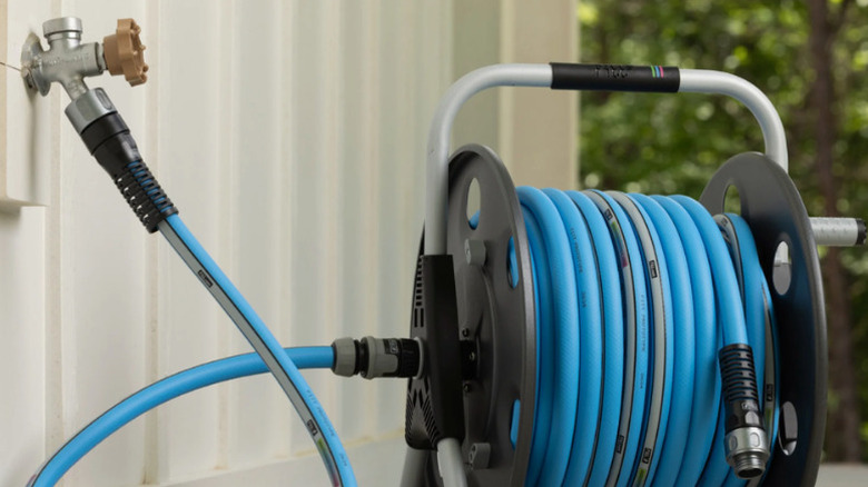FITT's Quantum Tech Metal Hose Reel plugged into an outdoor tap in a garden