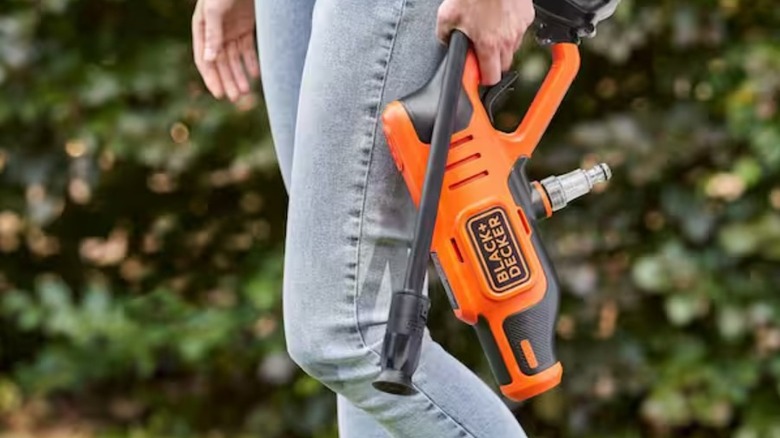 Man carrying the Black and Decker 20V pressure washer