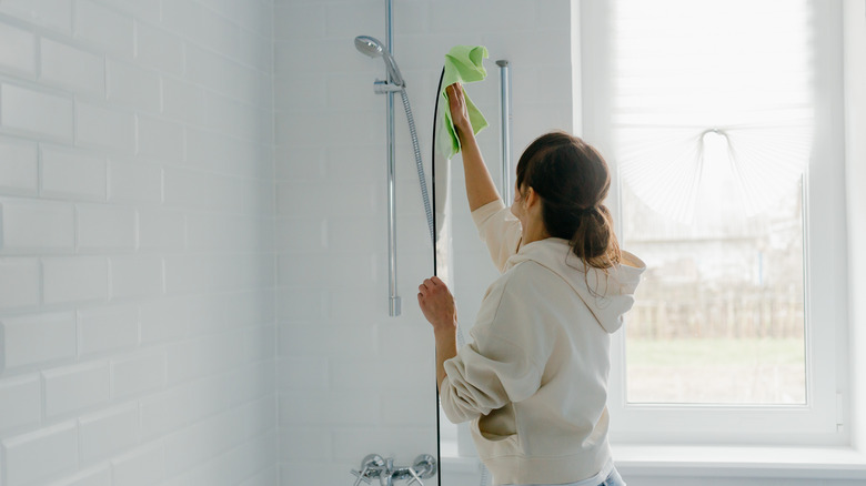 woman cleaning a shower door