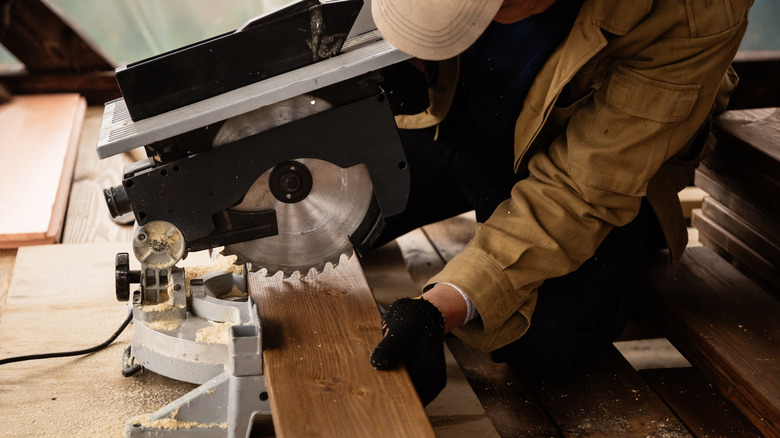 carpenter using miter saw