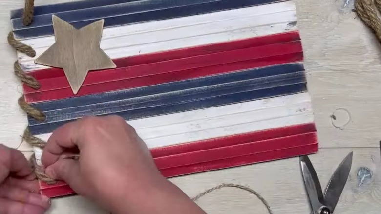 Person creates flag decor using wooden rulers from Dollar Tree