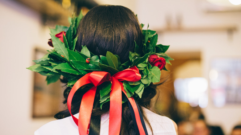 A person wearing a laurel wreath with a large decorative bow