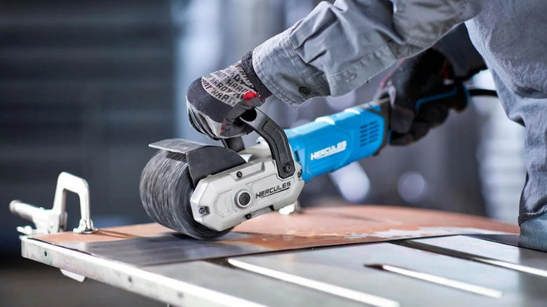A close-up of a worker using a surface conditioning tool from Hercules