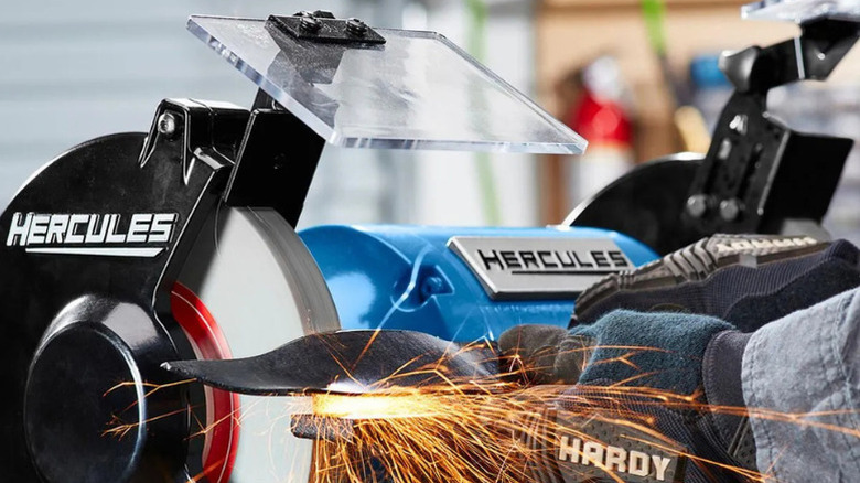 Sparks flying as worker uses a Hercules bench grinder to grind metal
