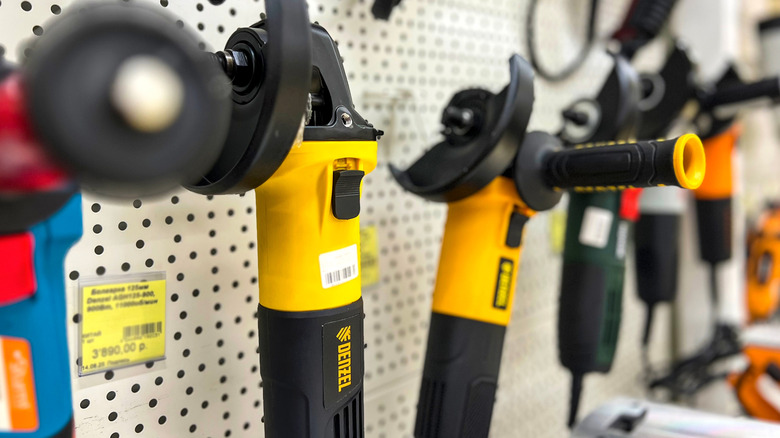 A row of power tools hanging on a shop wall