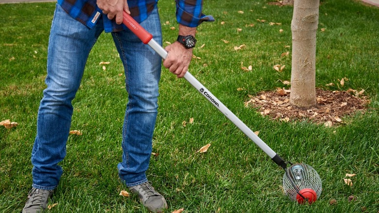 Person using Corona QuickCollector Ground Clearing Tool on lawn